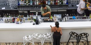 Μπάρμαν μιλάει με πελάτισσα σε μαγαζί στη Κέρκυρα
