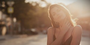 Νεαρή γυναίκα με καφέ ραντάκι μπλούζα κόντρα στον ήλιο