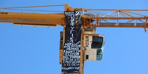Πανό για τα προσφυγικά σε γερανό