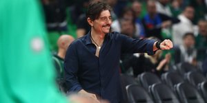 Ο Δημήτρης Γιαννακόπουλος δίνει χαμογελαστός φιλικά τη γροθιά του για χειραψία κατά τη διάρκεια αγώνα του Παναθηναϊκού