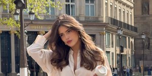 νέα γυναίκα μακριά μαλλιά λευκό πουκάμισο βερμούδα μαύρη τσάντα γυαλιά ηλίου στον δρόμο