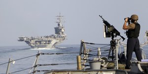 Στρατιώτης παρακολουθεί πολεμικά πλοία στα Στενά του Ορμούζ 