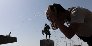 Άνδρας ρίχνει νερό στο πρόσωπό του εν μέσω καύσωνα