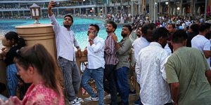 Νεαροί με κινητά βγάζουν selfie έξω από το εμπορικό κέντρο Dubai Mall, Ντουμπάι, Ηνωμένα Αραβικά Εμιράτα, 27 Μαΐου 2026. (AP Photo/Fatima Shbair)