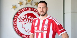 Ο Φορτούνης μπροστά στο σήμα του Ολυμπιακού