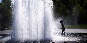 Ένα παιδί δροσίζεται σε σιντριβάνι μπροστά από τον Καθεδρικό Ναό του Βερολίνου