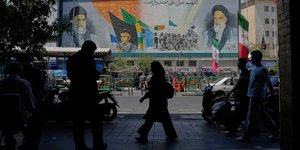 Πεζοί στην Τεχεράνη περπατούν μπροστά από τοιχογραφία του Αγιατολάχ Χομεϊνί και του Αλί Χαμενεΐ