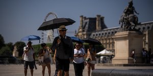 Κόσμος με ομπρέλες στο Παρίσι λόγω του καύσωνα