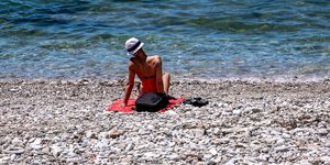 Γυναίκα κάνει ηλιοθεραπεία σε παραλία