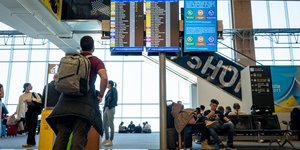 Επιβάτης κοιτάζει πίνακα αναχωρήσεων σε αεροδρόμιο