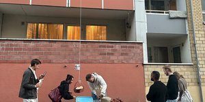 Οι πελάτες που περιμένουν από κάτω, παραλαμβάνουν τις πίτσες τους μέσω μίας τροχαλίας