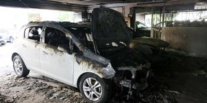 Καμένα οχήματα στην πυλωτή της κατοικίας της οικογένειας Νέστορα, στη Θεσσαλονίκη, μετά από βομβιστική επίθεση