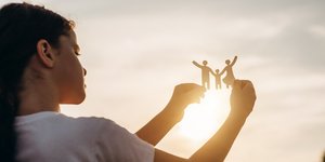 Παιδί στον ήλιοι με χάρτινη οικογένεια