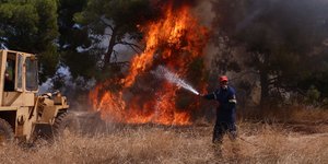 Πυροσβέστης σβήνει φωτιά στα Μέγαρα