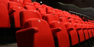 Η εικόνα με σειρές ολόκληρες από κόκκινα καθίσματα είναι τόσο συνηθισμένη που σπάνια αναρωτιόμαστε γιατί αυτό το χρώμα μοιάζει να έχει το μονοπώλιο / UNSPLASH