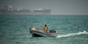 Με φόντο ένα δεξαμενόπλοιο υγραερίου LPG, ένας στρατιώτης της Υεμένης στα νερά βόρεια του στενού Μπαμπ ελ-Μαντέμπ, στη Μόκα