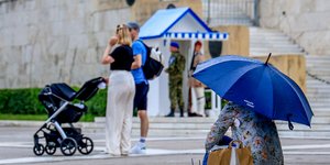 Ατομο με ομπρέλα μπροστά στο μνημείο του Άγνωστου Στρατιώτη