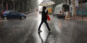Γυναίκα περπατά με ομπρέλα