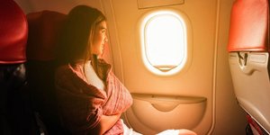 Γυναίκα κοιτάζει έξω από το παράθυρο αεροπλάνου/Φωτογραφία Shutterstock