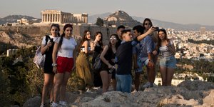 Τουρίστες ποζάρουν με φόντο την Ακρόπολη (Φωτογραφία αρχείου: AP/Petros Giannakouris)