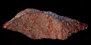 To θραύσμα βράχου με τις διασταυρούμενες γραμμές από κόκκινη ώχρα εντοπίστηκε στο σπήλαιο Μπλόμπος (Φωτογραφία: ΑΡ) 