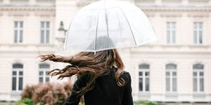 Μια γυναίκα ποζάρει στο φακό μια βροχερή ημέρα/ Φωτογραφία: Shutterstock