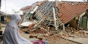 Μια σεισμόπληκτη θρηνεί στα ερείπια του σπιτιού της στο Λομπόκ (Φωτογραφία: ΑΡ) 