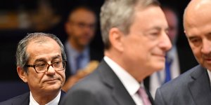 O Ιταλός υπουργός Οικονομικών Τζιοβάνι Τρία (αριστερά) με το βλέμμα στον Μάριο Ντράγκι και τον Πιερ Μοσκοβισί (Φωτογραφία: ΑΡ/Geert Vanden Wijngaert)