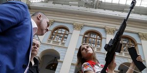 (Επισκέπτρια δοκιμάζει όπλο της Kalashnikov σε εκθεση ΑΠΕ/ EPA/ MAXIM SHIPENKOV)