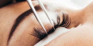 Γυναίκα βάζει ψεύτικες βλεφαρίδες/Φωτογραφία Shutterstock