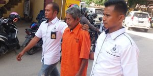 Αστυνομικοί συνοδεύουν τον 83χρονο σαμάνο στο τμήμα (Φωτογραφία: Jakarta Post) 