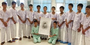 Tα παιδιά από το νοσοκομείο που αναρρώνουν φωτογραφίζονται κρατώντας σκίτσο του δύτη που πέθανε προσπαθώντας να τα σώσει/Φωτογραφία: ΑΡ