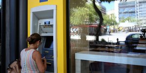 γυναίκα στο ΑΤΜ έξω από τράπεζα/Φωτογραφία: IntimeNews