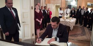 Ο Αλέξης Τσίπρας υπογράφει το βιβλίο επισκεπτών. 