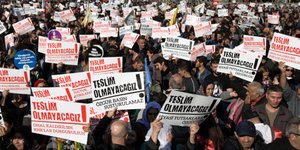 Φωτογραφία: AP/ Τα πλακάτ των Τούρκων διαδηλωτών γράφουν: «Δεν θα παραδοθούμε» 