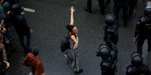 Γυναίκα στέκεται απέναντι στους αστυνομικούς. Πηγή φωτό: AP/Emilio Morenatti