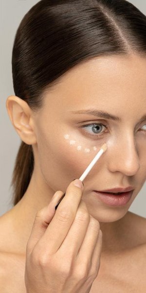 Γυναίκα που βάζει concealer 