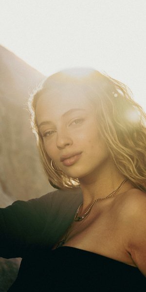 Νεαρή γυναίκα με ξανθά μαλλιά κάτω από τον ήλιο