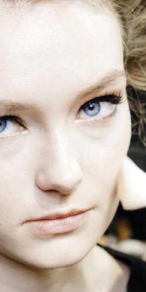 νεαρό μοντέλο με ρόλει στα μαλλιά και γαλάζια μάτια με eyeliner