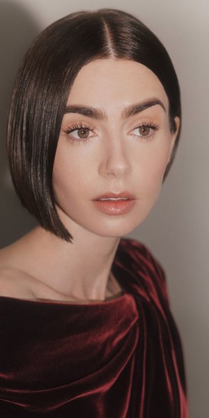 η λίλι κόλλινς με μπορντό βελούδινο φόρεμα και καρέ μαλλιά