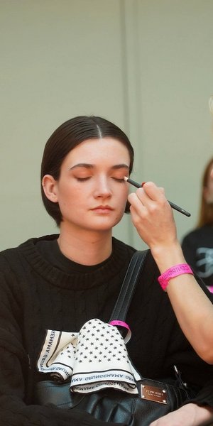 μοντέλο και μακιγιέζ backstage σε επίδειξη μόδας