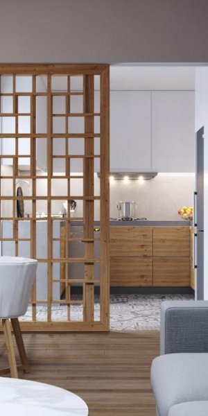 Το συρόμενο, διάτρητο διαχωριστικό από ξύλο επιτρέπει τη διακριτική οριοθέτηση της κουζίνας από το καθιστικό/ Φωτογραφία: Κυριακή Καπασακαλίδου